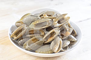 Closeup uncooked clams on a white dish