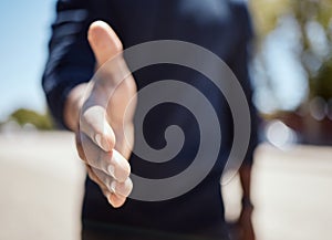 Closeup of an unknown businessman holding his hand out for a handshake in a outside in the city. Closeup of an unknown