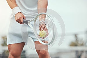 Closeup of unknown mixed race tennis player getting ready to serve on court. Hispanic fit athlete holding racket and a