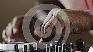 Closeup unrecognizable male DJ sound engineer musician playing house electronic music on console panel twirls sound