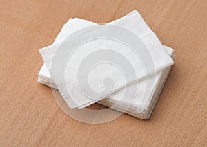 Stack of unwrapped wet wipes on wooden table photo