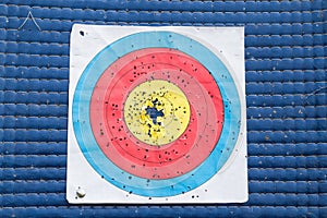 Closeup on used and worn out outdoor archery target board