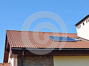 Closeup of Vacuum Solar Water Heating System Rain Gutter on the Red Tiled House Roof