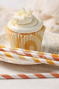 Closeup of vanilla cupcake with straws