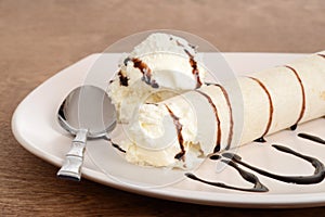 Closeup vanilla ice cream crepe with chocolate sauce and spoon