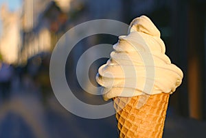 Vanilla Soft Serve Ice Cream Cone with Blurry Walking Street in Background