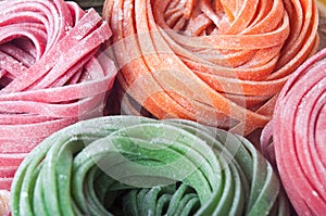 Closeup of varicolored raw italian pasta with vegetable dyes