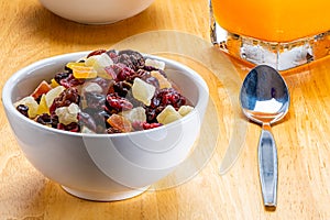 Closeup of various dried tropical fruit in white ceramic bowl