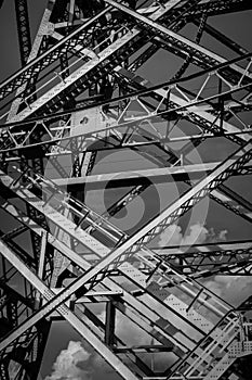 Closeup vertical shot of a steel metallic bridge construction in black and white