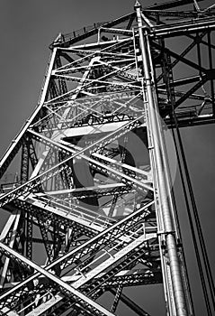 Closeup vertical shot of a steel metallic bridge construction in black and white