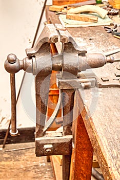 A closeup of an old vise in a workshop.