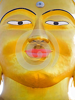 Closeup vibrant gold Shanti Ban Buddha face, golden Buddha`s image in Dhulikhel, Nepal