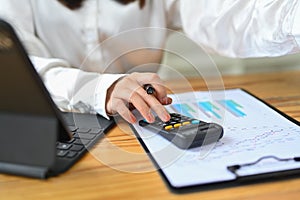 Closeup view of accountant working bookkeeping documents, checking financial data at office desk