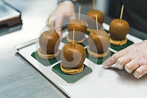 closeup view of apples covered with caramel and sticks into them, delecious dessert