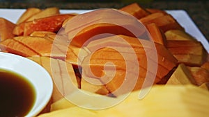 Closeup view on assortment of sliced tropical papaya fruits at food court