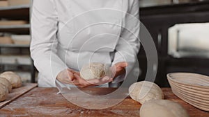 Closeup view on baker hands preparing formed bread dough for proofing