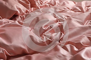 Closeup view of bed with beautiful pink silk linens