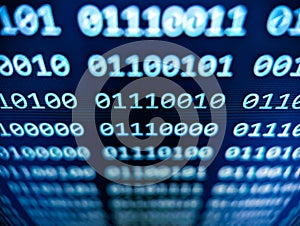 Closeup view of binary computer code with 1s and 0s displayed on a blue screen with focus blur effect