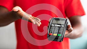 Closeup view of black man holding POS machine for payment