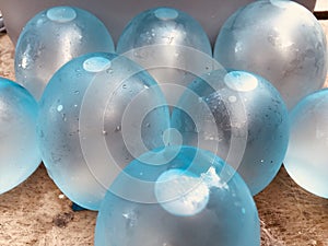 closeup view of blue balloons filled with water, wet