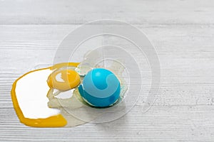 Closeup view of broken Easter blue egg with the leaked yolk on the floor