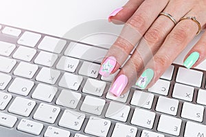 Closeup view of a business woman hand typing on wireless computer keyboard on office table.