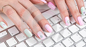 Closeup view of a business woman hands typing on wireless computer keyboard on office table