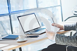 Closeup view of businessman in eyeglasses working at office on laptop while sitting at the wooden table.Coworker anazyle