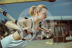 Closeup view of cheerful woman doing push ups urban workout for arms