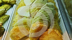 Closeup view on cleaned tropical pineaple slices at food court assortment