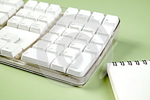 Closeup view of a computer keyboard with an empty notebook