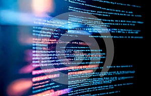closeup view of computer screen showing lines of digital code. Blurred image essence of data processing, with visible lines of