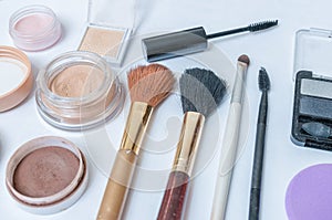 Closeup view on cosmetics, makeup and brushes on white background
