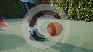 closeup view of dribbling basketball ball, african american man is playing with orange ball