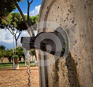 Closeup view of drinking fountain in a shape of wolf`s head in the Orange trees Garden in Rome