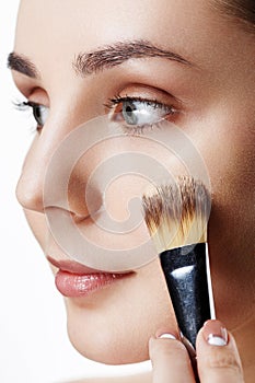 Closeup view of face of Beauty Girl with Makeup Brushes. Natural