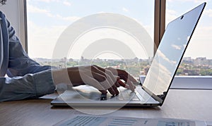 Closeup view of female businesswoman typing on laptop computer keyboard.