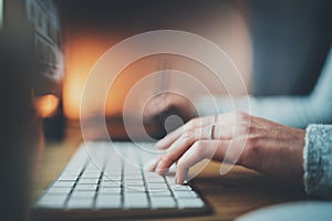 Closeup view of female hands typing keyboard.Selective focus on hand.Blurred background.Horizontal.