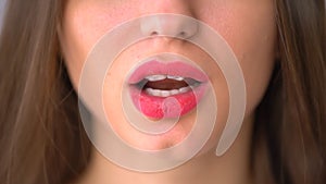 Closeup view of female mouth chewing gum. Woman with red lips and bad manners