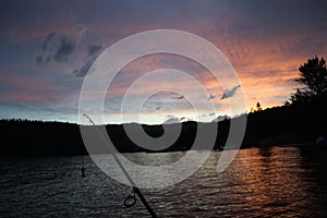 Closeup view of a fishing rod, on the lake shore at sunset in Somers town, Montana, USA photo