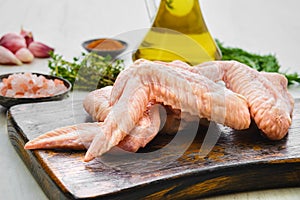 Closeup view of fresh uncooked chicken wings on cutting board ready for cooking