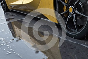 A closeup view of a GT race cars large tires and rims providing superior grip on both wet and dry racetracks. Speed