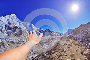 Closeup view of hand on beautiful panoramic mountain view of Everest Region