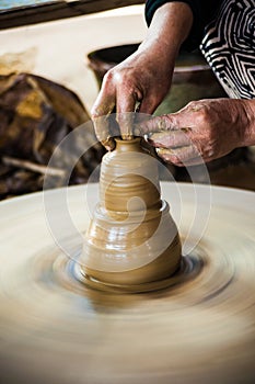 Closeup view of hands of an old asian potter