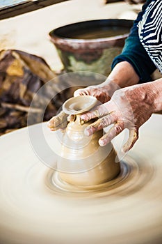 Closeup view of hands of an old asian potter
