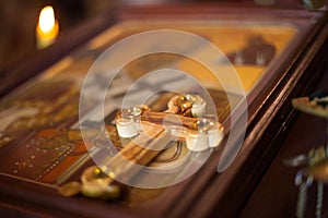 Closeup view of a holy wooden Christian cross on a blurred icon