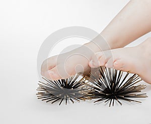 Closeup view of human feet doing massage therapy on artificial sea urchins model