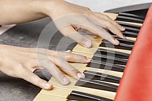Closeup view of human hand playing electronic piano keyboard