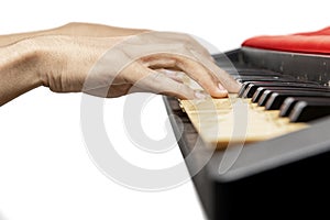 Closeup view of human hand playing electronic piano keyboard