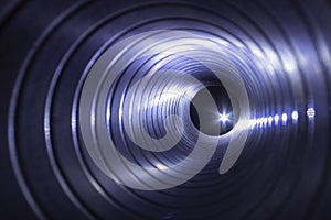 Closeup view from inside the galvanized steel air duct on the exhaust fan in the background light, the front and back background